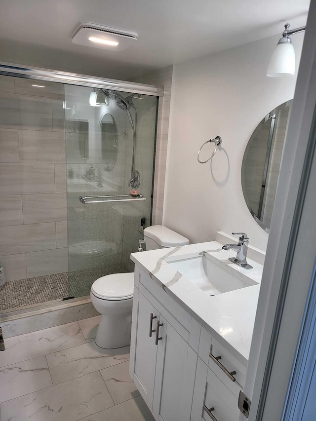 bathroom featuring walk in shower, vanity, and toilet