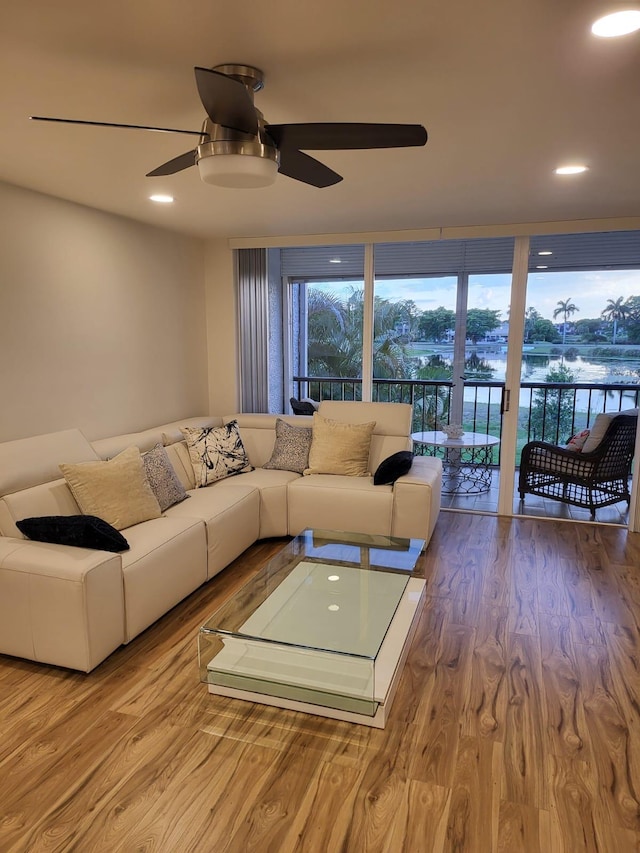 living room with light hardwood / wood-style flooring and ceiling fan