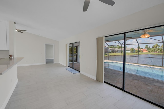 5625 Aspen Ridge Cir, Delray Beach, FL 33484 - empty room featuring a ceiling fan, vaulted ceiling, baseboards, a water view, and a sunroom