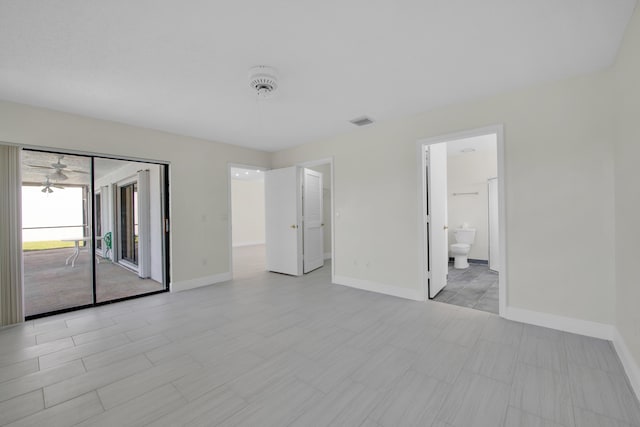 unfurnished bedroom with baseboards, access to outside, ensuite bathroom, and visible vents