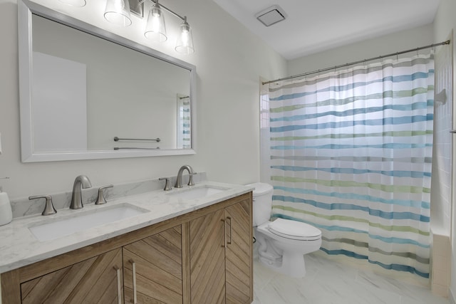 full bathroom featuring marble finish floor, double vanity, toilet, and a sink