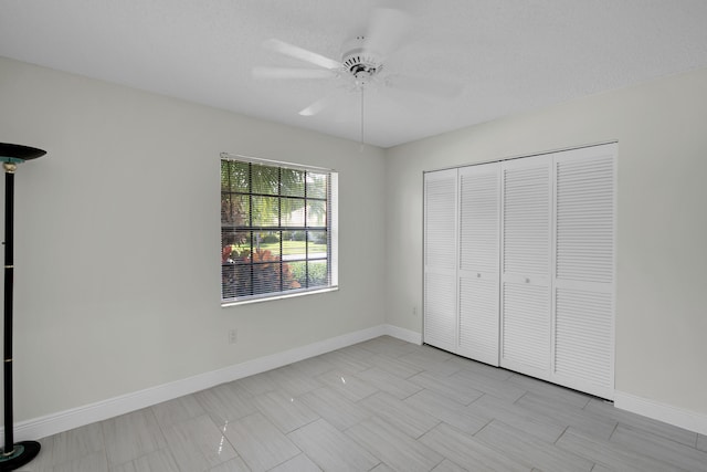 unfurnished bedroom with a textured ceiling, a closet, and ceiling fan