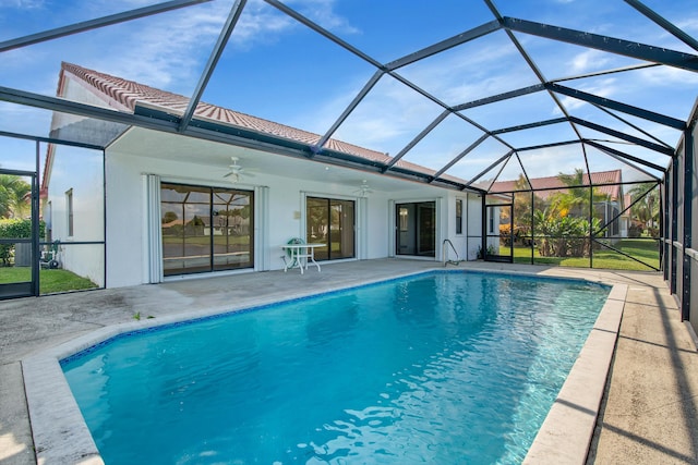 outdoor pool featuring glass enclosure, a ceiling fan, and a patio area