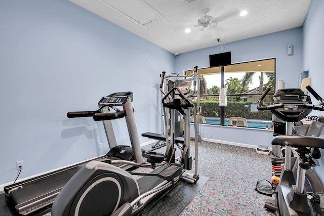 workout area featuring a textured ceiling, carpet, and ceiling fan