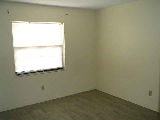 spare room with a textured ceiling and hardwood / wood-style floors