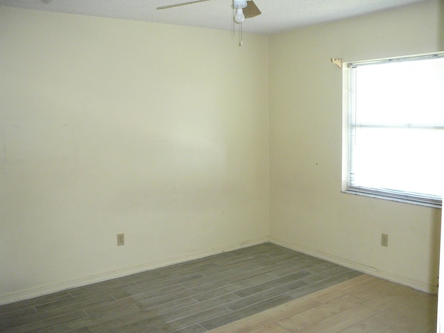 spare room with ceiling fan, hardwood / wood-style flooring, and a textured ceiling