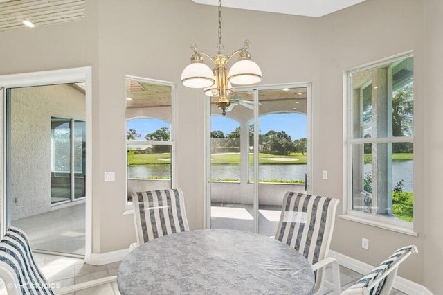 dining room featuring a notable chandelier, a water view, and a wealth of natural light