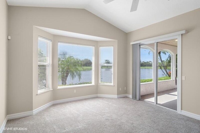 carpeted spare room with a water view, ceiling fan, and a healthy amount of sunlight