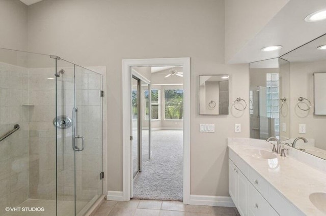 bathroom featuring tile patterned flooring, vanity, ceiling fan, and an enclosed shower