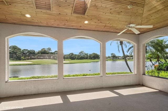 unfurnished sunroom with wooden ceiling, a healthy amount of sunlight, a water view, and ceiling fan