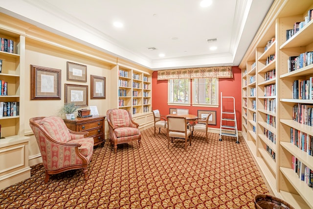 living area featuring carpet floors, crown molding, a tray ceiling, and built in features