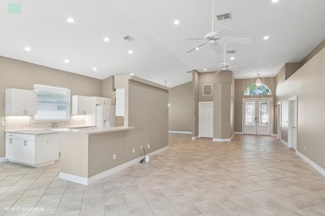 kitchen featuring ceiling fan, white cabinets, white refrigerator, french doors, and high vaulted ceiling