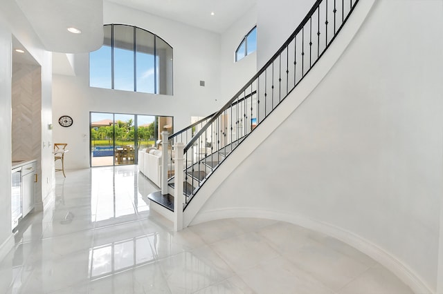 staircase with a high ceiling and plenty of natural light