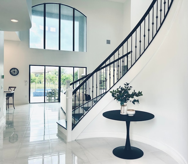 staircase featuring a towering ceiling