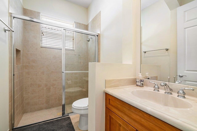 bathroom with toilet, vanity, and walk in shower