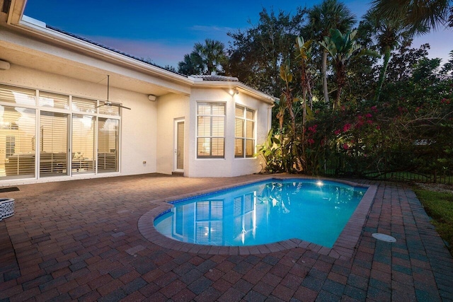 pool at dusk featuring a patio area