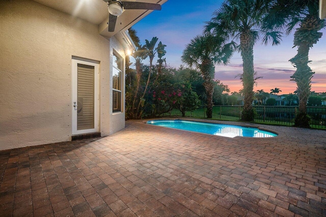 pool at dusk featuring a patio