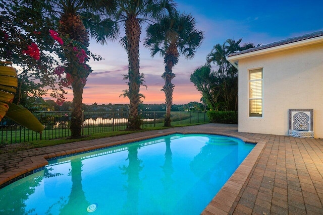 pool at dusk with a patio