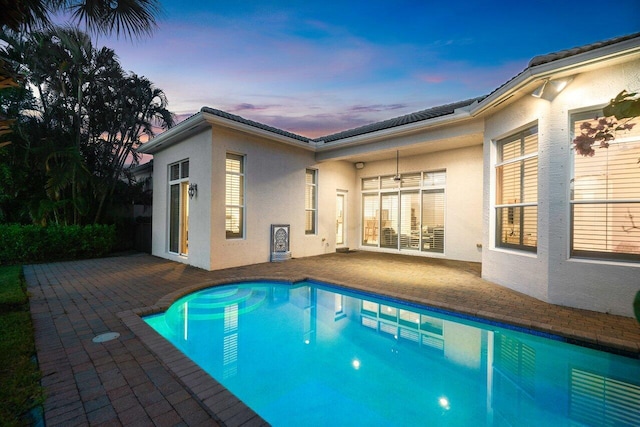 pool at dusk with a patio