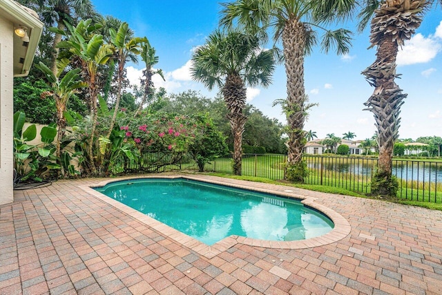 view of swimming pool featuring a patio and a water view