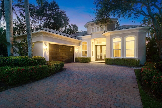 101 Dalena Way, Palm Beach Gardens, FL 33418 - mediterranean / spanish-style home with french doors, a garage, stucco siding, and a tiled roof