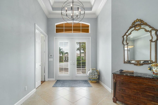 tiled entrance foyer with an inviting chandelier, french doors, and crown molding