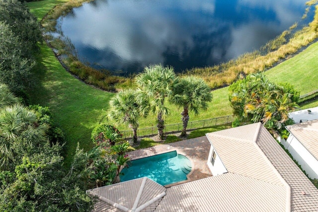 view of swimming pool featuring a yard and a water view