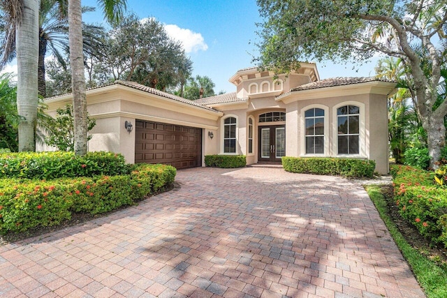 101 Dalena Way, Palm Beach Gardens, FL 33418 - mediterranean / spanish home with french doors, an attached garage, stucco siding, decorative driveway, and a tiled roof