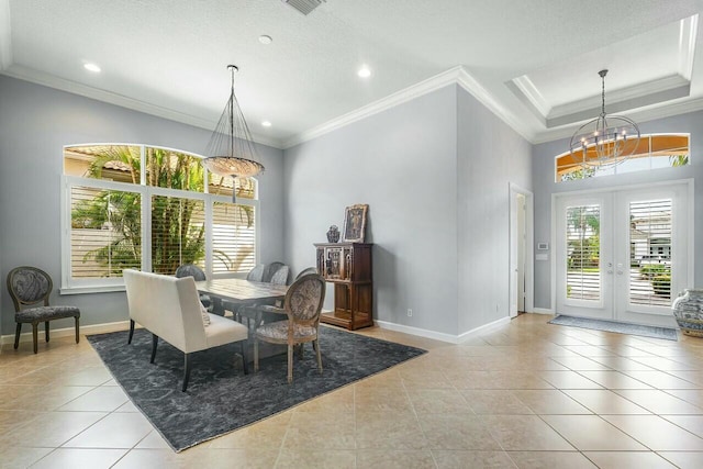 dining space featuring light tile patterned floors, a chandelier, a tray ceiling, crown molding, and french doors