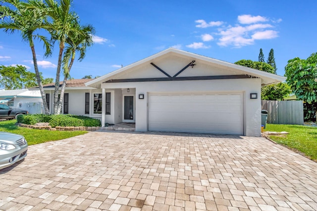 single story home featuring a garage and a front yard