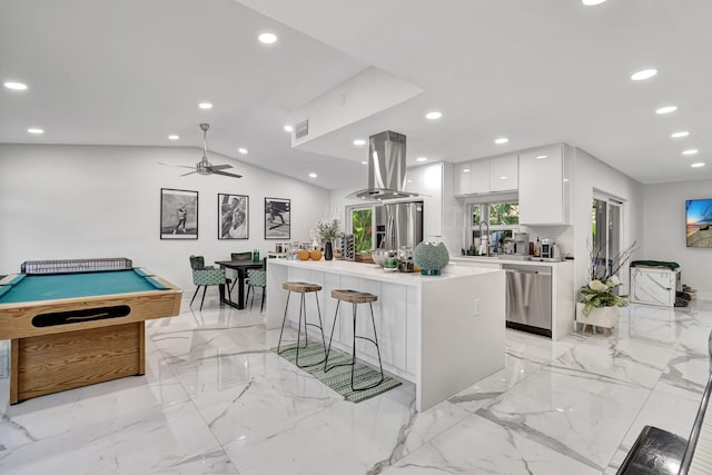 kitchen featuring lofted ceiling, white cabinetry, island range hood, a kitchen island, and stainless steel appliances