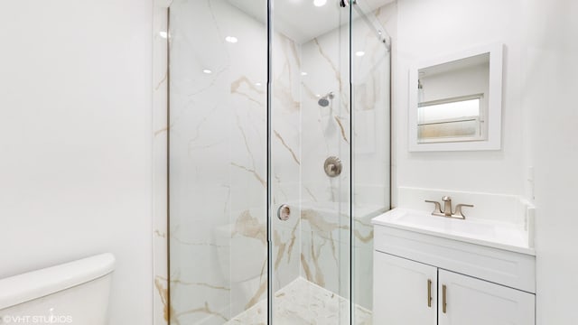 bathroom with walk in shower, vanity, and toilet