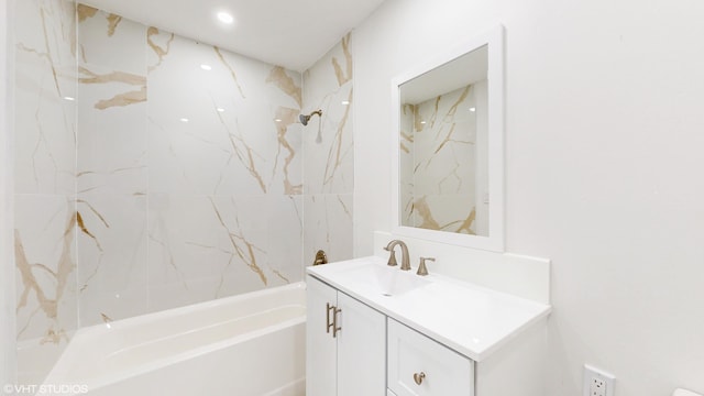 bathroom featuring tiled shower / bath combo and vanity