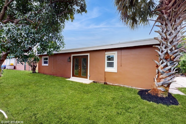 rear view of property featuring french doors and a yard