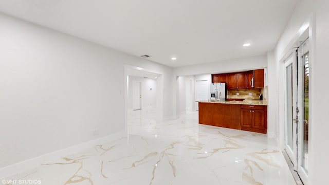 kitchen with backsplash and stainless steel fridge