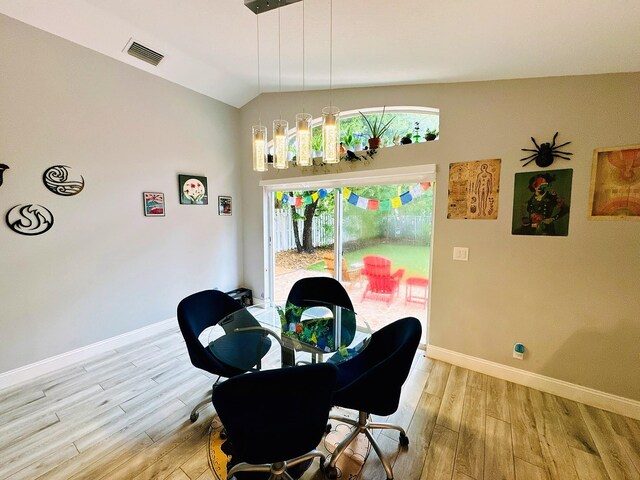 dining area with vaulted ceiling and light hardwood / wood-style flooring