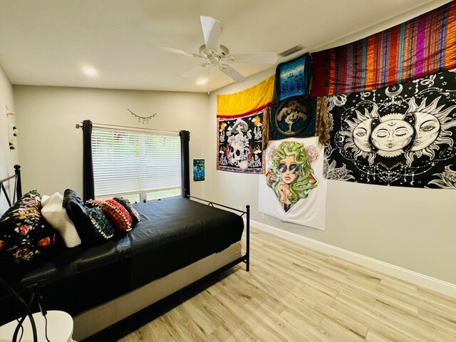 bedroom with ceiling fan, vaulted ceiling, and light hardwood / wood-style floors