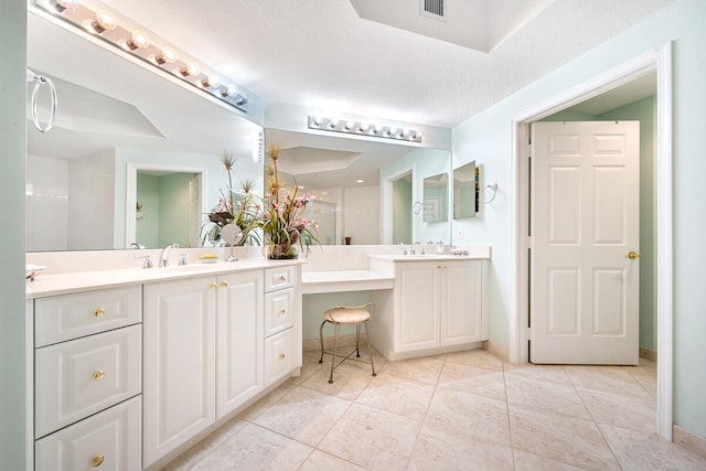 bathroom featuring tile patterned flooring, a textured ceiling, and vanity