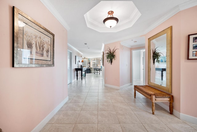 corridor with a tray ceiling, crown molding, and light tile patterned floors