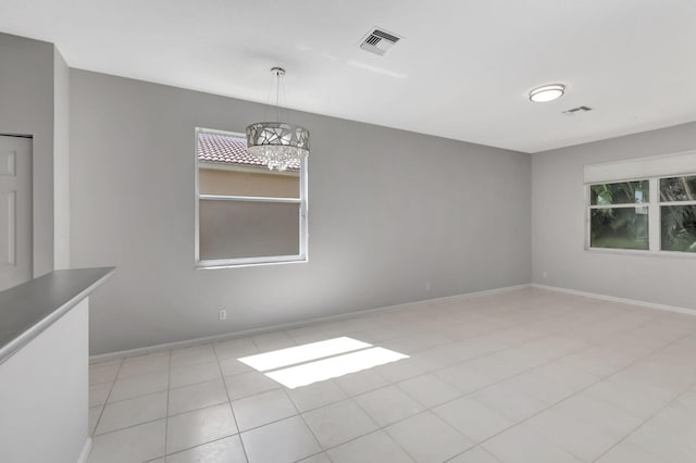 unfurnished dining area featuring a chandelier, light tile patterned floors, and a healthy amount of sunlight