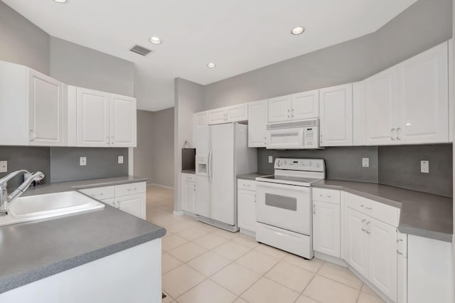 kitchen featuring light tile patterned floors, sink, white appliances, and white cabinetry