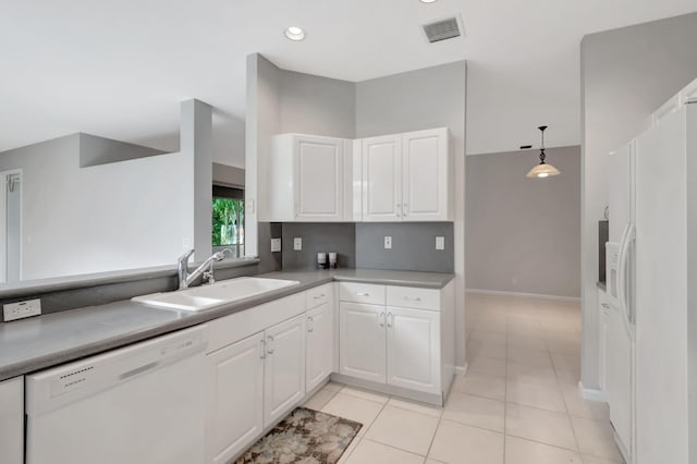 kitchen featuring white cabinets, light tile patterned flooring, sink, white appliances, and decorative light fixtures