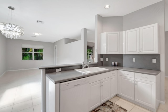 kitchen featuring white dishwasher, sink, kitchen peninsula, a chandelier, and white cabinetry