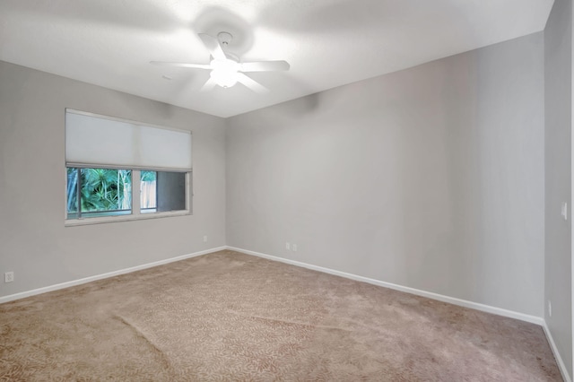 empty room featuring ceiling fan and light colored carpet