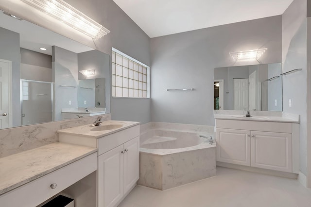 bathroom featuring vanity and independent shower and bath