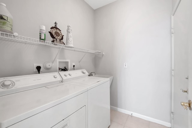 laundry room featuring washing machine and clothes dryer, sink, and light tile patterned floors