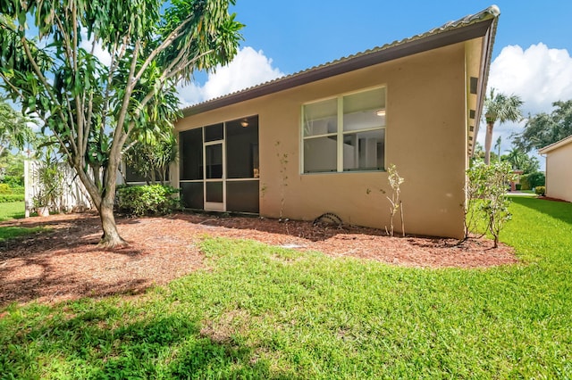 rear view of property with a sunroom and a yard