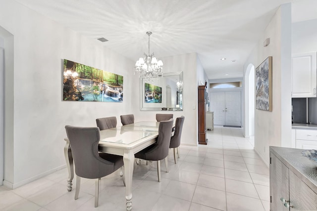 tiled dining room with a notable chandelier