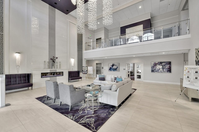 living room with a high ceiling, light tile patterned flooring, and an inviting chandelier