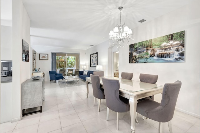 dining room with light tile patterned floors and an inviting chandelier